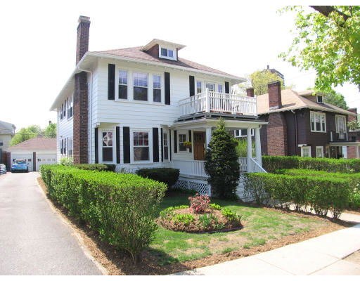 Front view of a two-story house with a balcony and chimney.