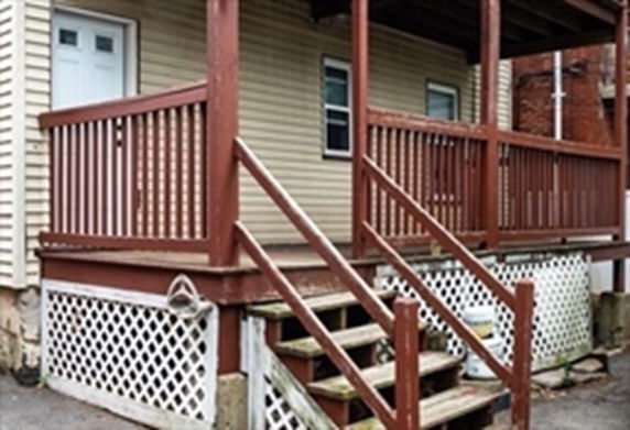 Front view of a house with a wooden porch and steps.