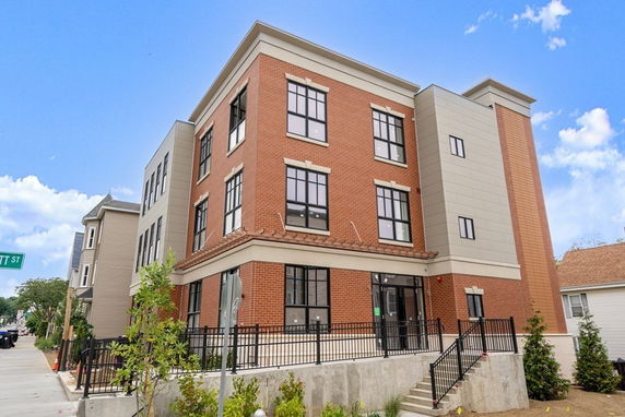 Front view of a multi-story building with brick and panel exterior.