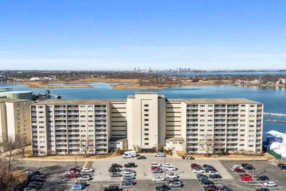 Front view of a large multi-story apartment building with numerous balconies.