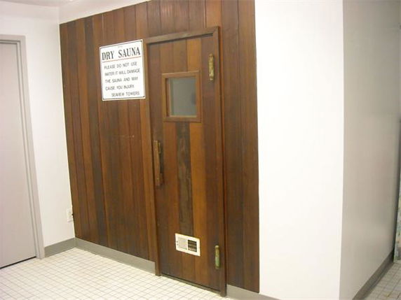 Entrance to a dry sauna room with a wooden door and sign.