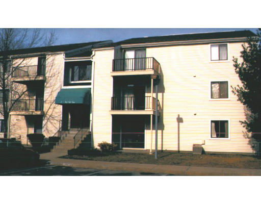 Front view of a multi-story apartment building with balconies and stairs.