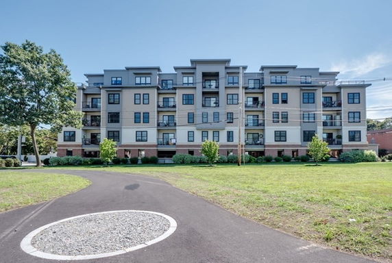 Front view of a multi-story apartment building with multiple balconies.