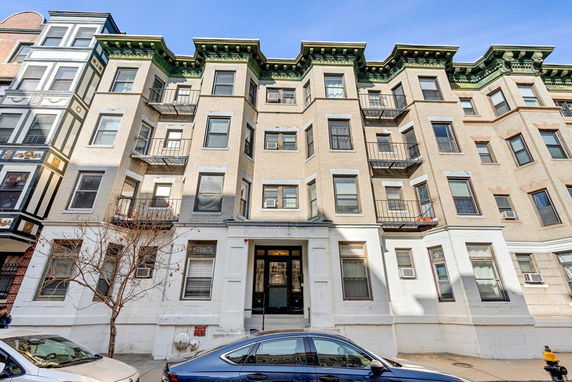 Front view of a multi-story residential building with decorative elements.