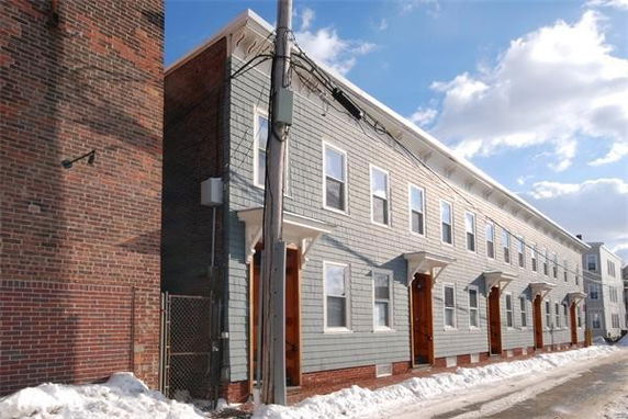 Front view of a long row of attached houses with uniform design.