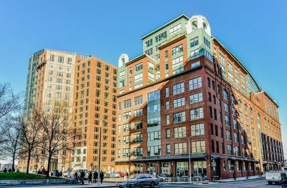 Front view of a multi-story urban building with large windows and brick facade.