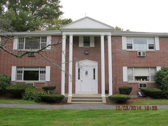 Front view of a two-story brick building with columns at the entrance.