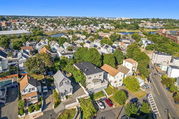 Panoramic view of a suburban neighborhood with multiple houses and surrounding greenery.