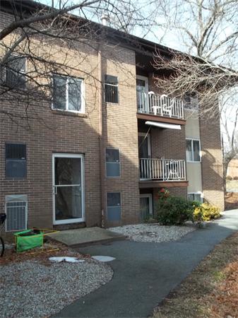 Front view of a three-story apartment building with balconies.