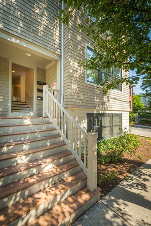 Front view of a house with an exterior staircase leading to the entrance.