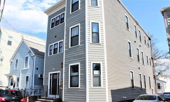 Front view of a three-story house with multiple windows.