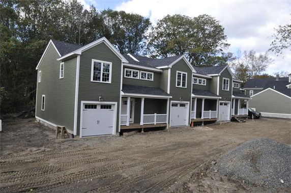 Front view of a row of two-story houses with garages.