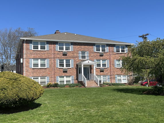 Front view of a multi-story brick apartment building.