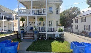Front view of a two-story house with a covered porch and balcony.