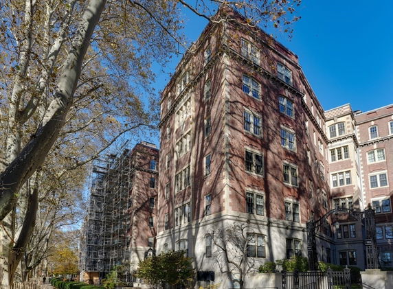 Front view of a multi-story brick building with large windows.