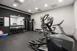 Indoor gym area with exercise equipment and free weights.
