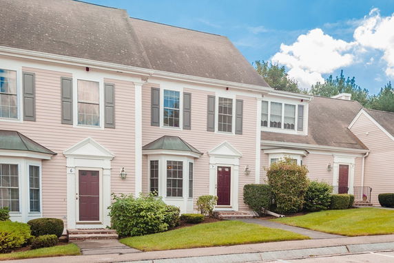 Front view of a multi-story townhouse with a gabled roof and dormer windows.