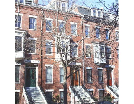 Front view of a multi-story brick building with staircase entrances.