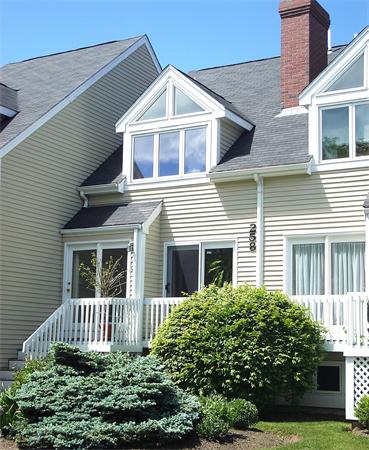 Front view of a two-story house with triangular windows and a chimney.
