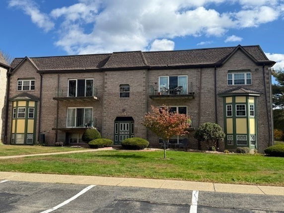 Front view of a two-story brick apartment building with balconies.