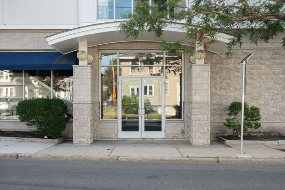 Front view of a building with glass doors and stone facade.