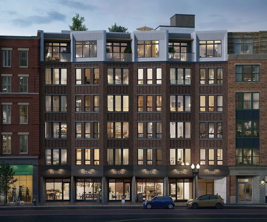 Front view of a multi-story building with retail spaces on the ground floor.