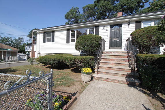 Front view of a single-story house with stairs leading to the entrance.
