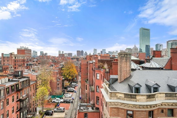 Panoramic view of urban rooftops and distant city skyscrapers.
