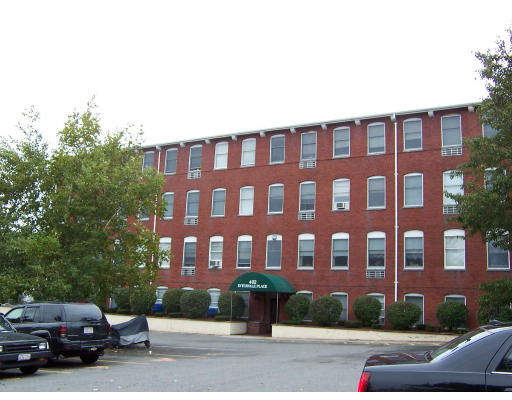 Front view of a four-story brick building with multiple windows.