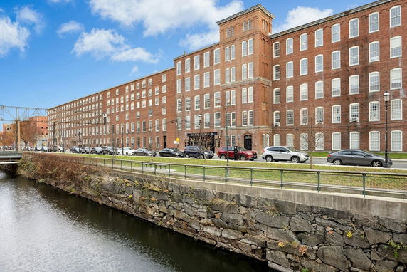 Front view of a large brick building with multiple windows and a tower section.