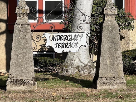Front view of a building with a sign labeled 'Undercliff Terrace' mounted between two stone pillars.