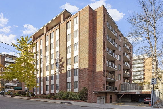 Front view of a multi-story brick building with balconies.
