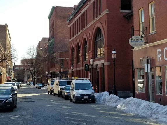 Street view of brick buildings with arched windows.