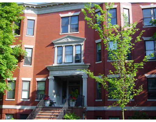 Front view of a multi-story brick building with a prominent entrance and steps.