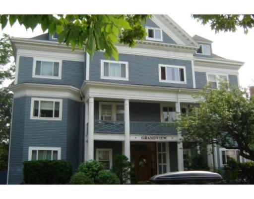 Front view of a multi-story blue building with a porch and white trim.