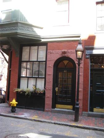 Front view of a building with a brick exterior and arched doorway.
