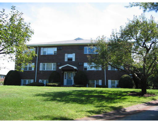 Front view of a three-story brick building with multiple windows.