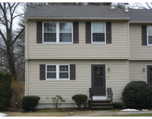 Front view of a two-story house with beige siding and dark shutters.