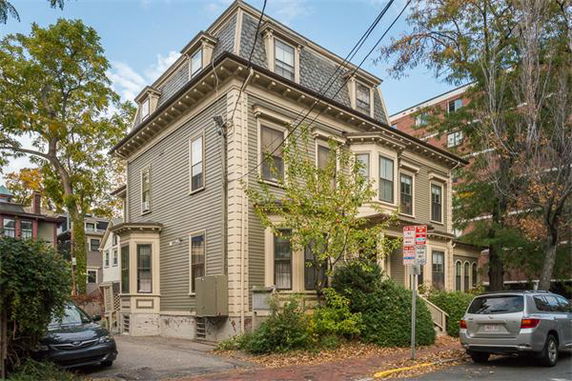 Front view of a two-story house with a classic design and mansard roof.
