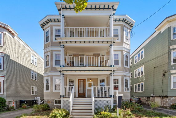 Front view of a multi-story residential building with balconies on each floor.