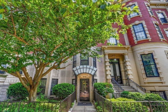Front view of a multi-story building with a decorative entrance and brick facade.