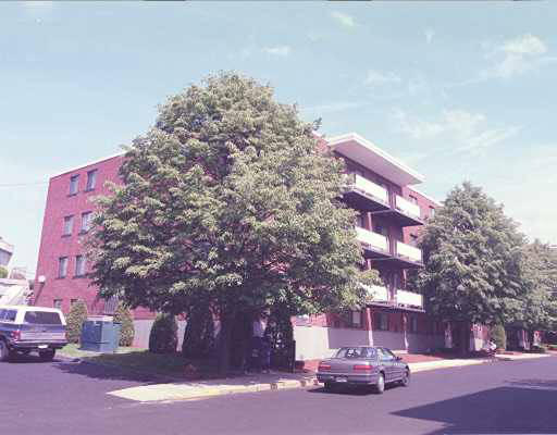 Front view of a multi-story apartment building with balconies.
