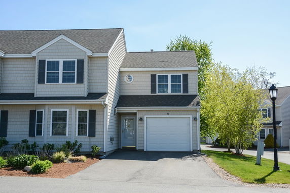 Front view of a house with an attached garage and dormer windows.