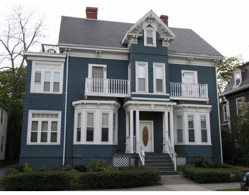 Front view of a two-story house with a gabled roof and multiple balconies.
