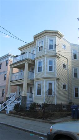 Front view of a three-story residential building with balconies.