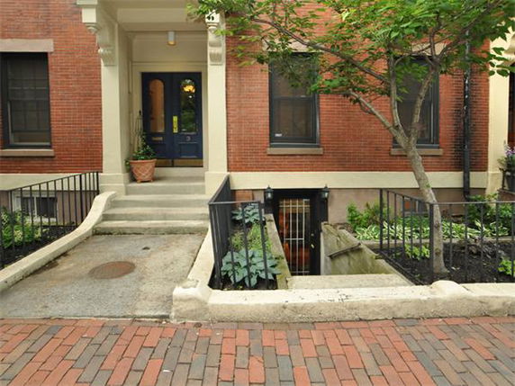 Front view of a brick building with steps leading to the entrance.
