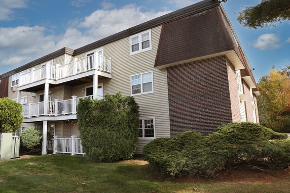 Front view of a multi-story building with balconies and a brick exterior.