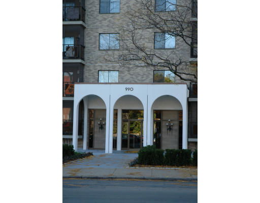 Front view of a multi-story building with a white entrance and arched doorways.
