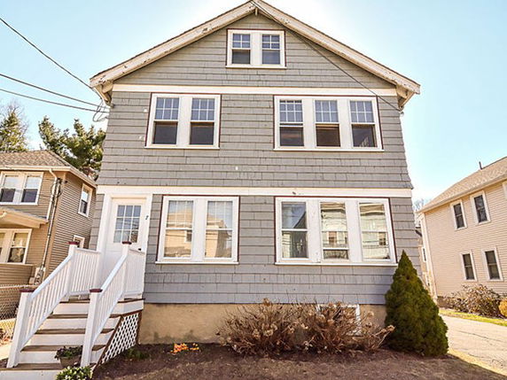 Front view of a two-story house with multiple windows and an entry staircase.