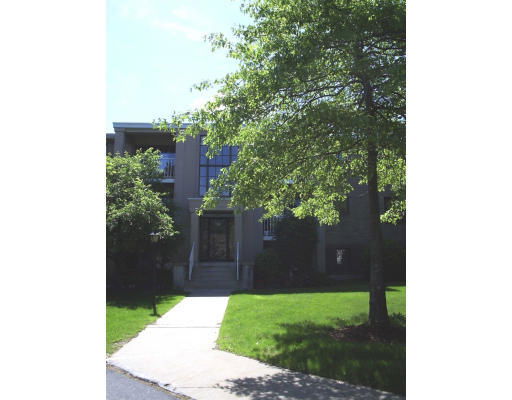 Front view of a two-story building with central entrance and surrounding trees.